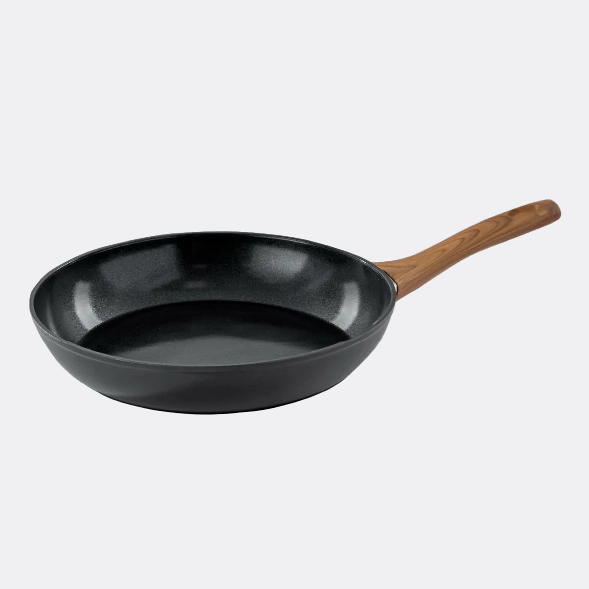 Black frying pan with a wooden handle on a light grey background